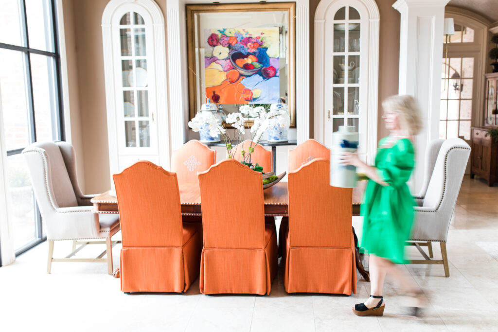 Realtor walking through dining room with a vase