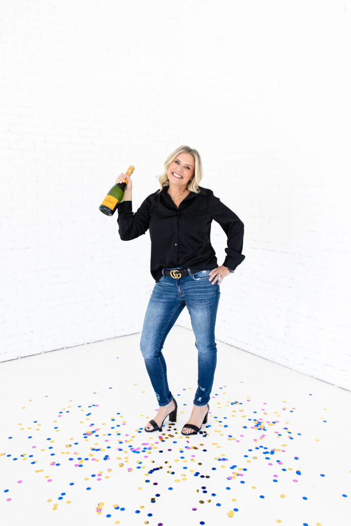 Subject celebrating in a clean white space with confetti and champagne 