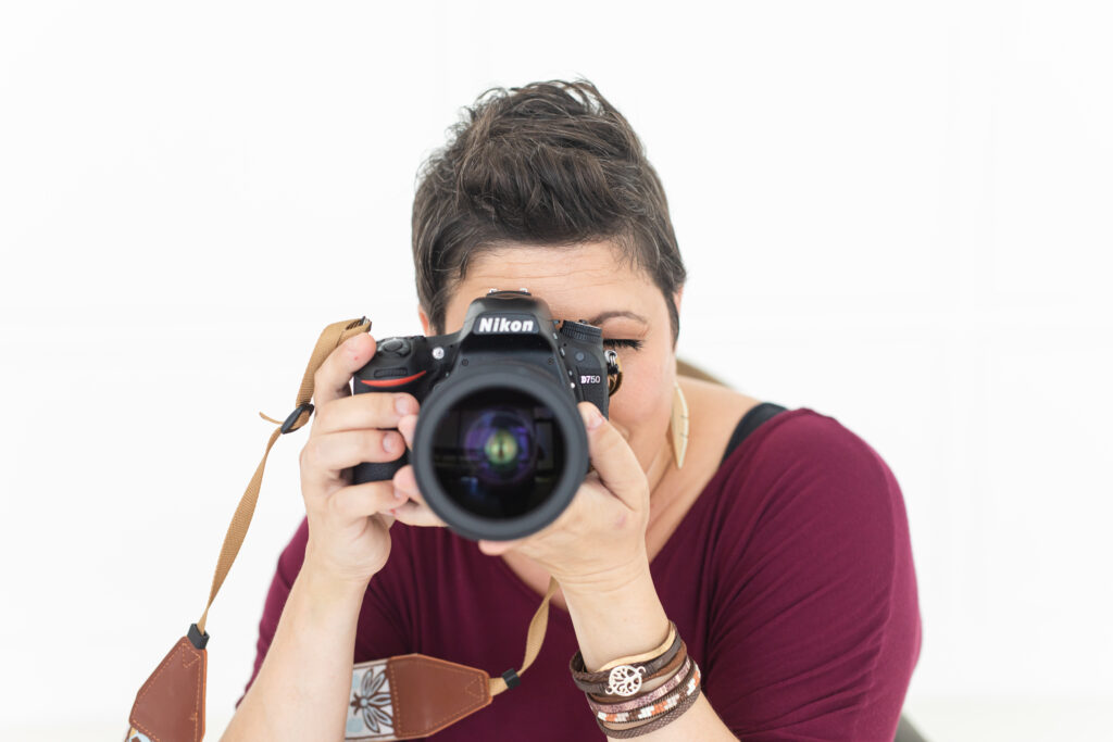 Detail shot: Entrepreneur photographer holding her camera.